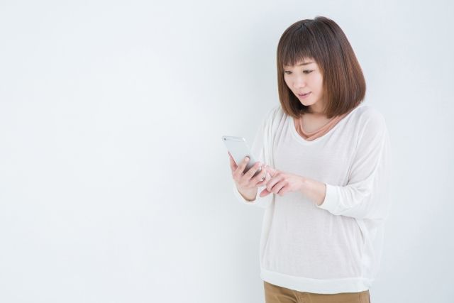 スマートフォンを見て驚く女性