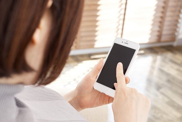 スマートフォンをタップする女性