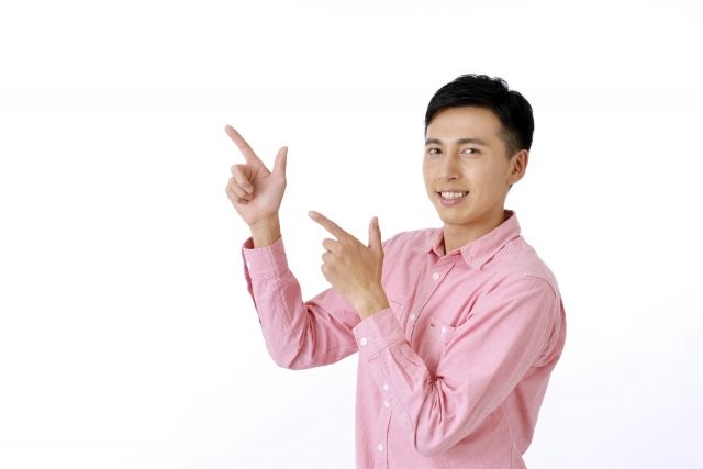 両手で指差す男性