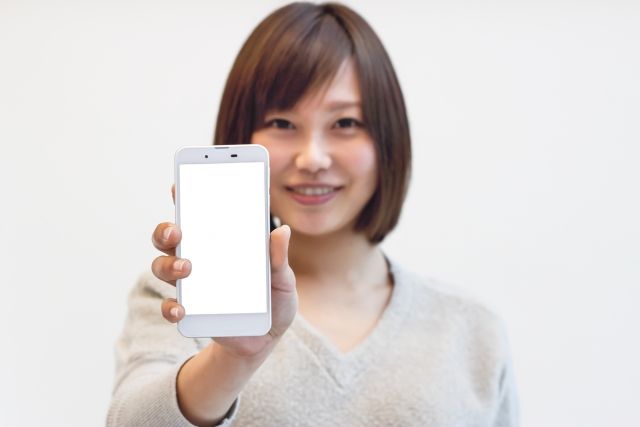 スマートフォンを見せる女性